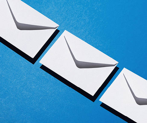 Envelopes pattern over blue background, above view with negative space