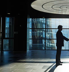 Two entrepreneurs handshaking in office center against window with sunlight penetrating inside